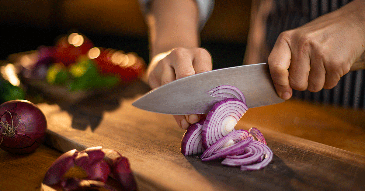 man chopping onion with kitchen knife