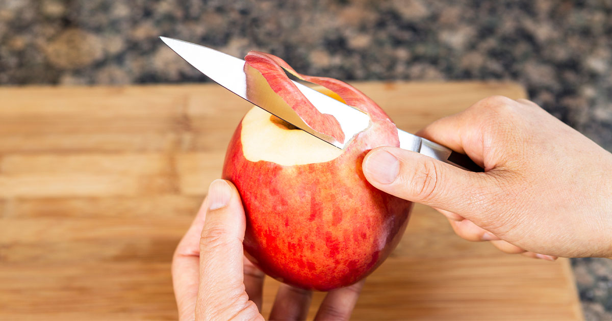 Guy cutting apple with kitchen knife