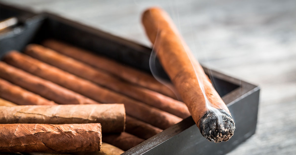 Lit cigar on cigar box