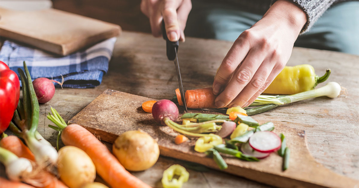Man cutting vegetables with kitchen knife