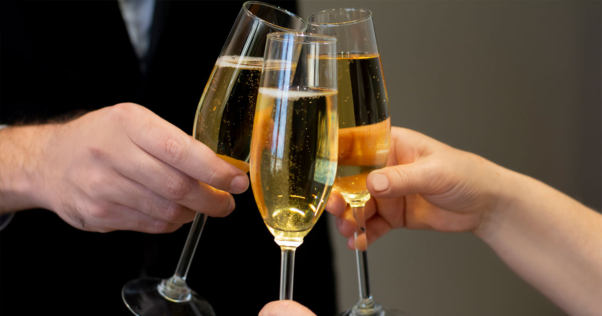 Three people cheersing with champagne glasses