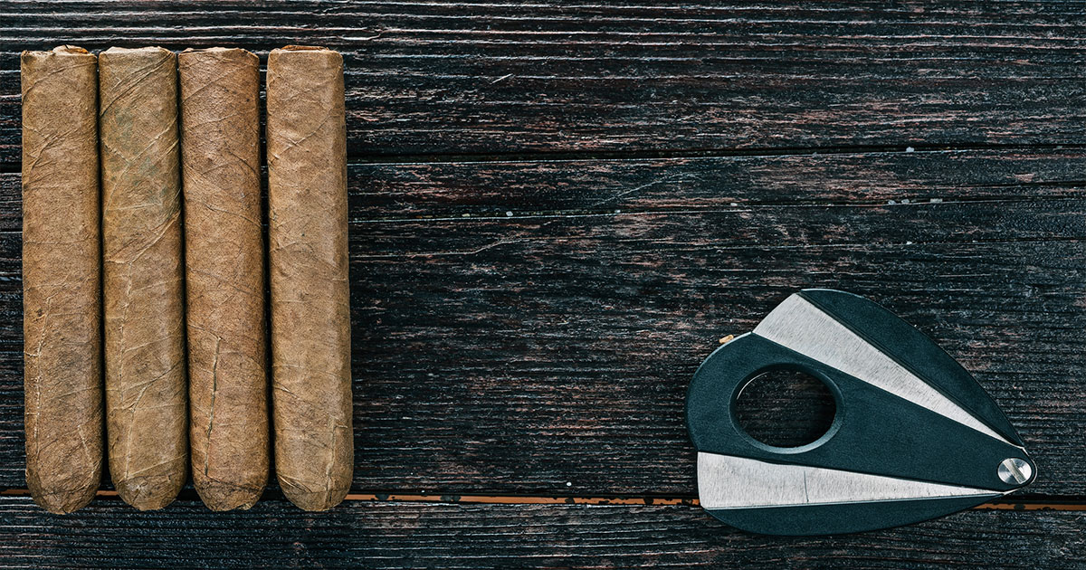Cut cigars on table with cigar cutter