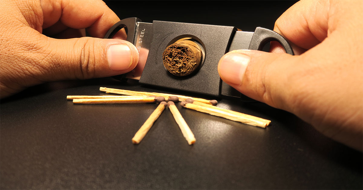 Cigar cutter with matches on table