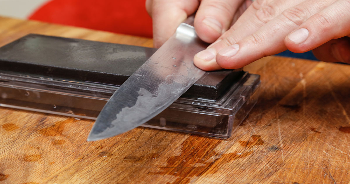 Man sharpening knife with whetstone