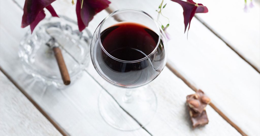 Lit cigar paired with red wine